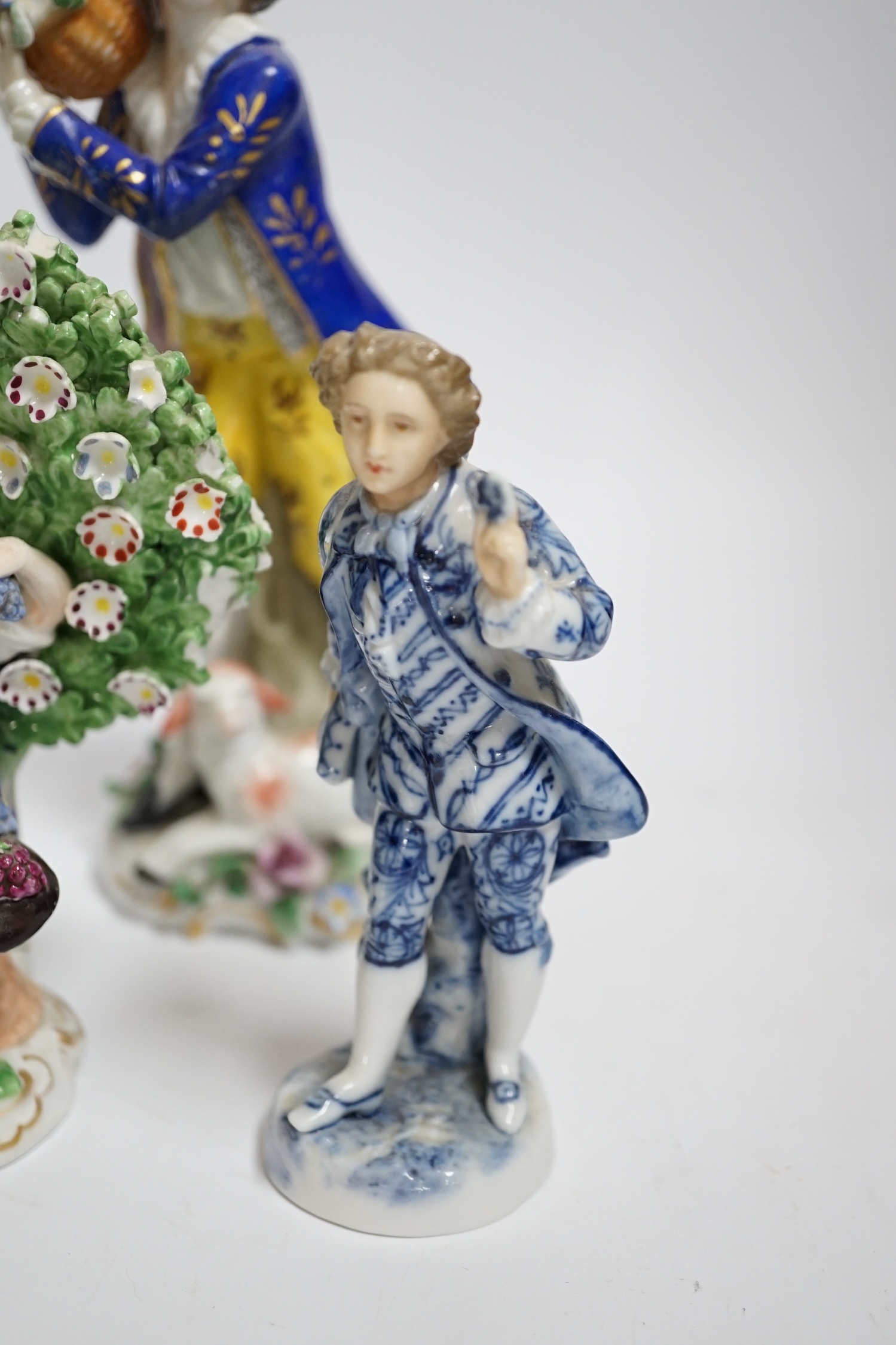 A pair of Derby style porcelain small bocage figures, a boy and girl seated with grape filled hats, height 14cm, three porcelain lambs and another figure